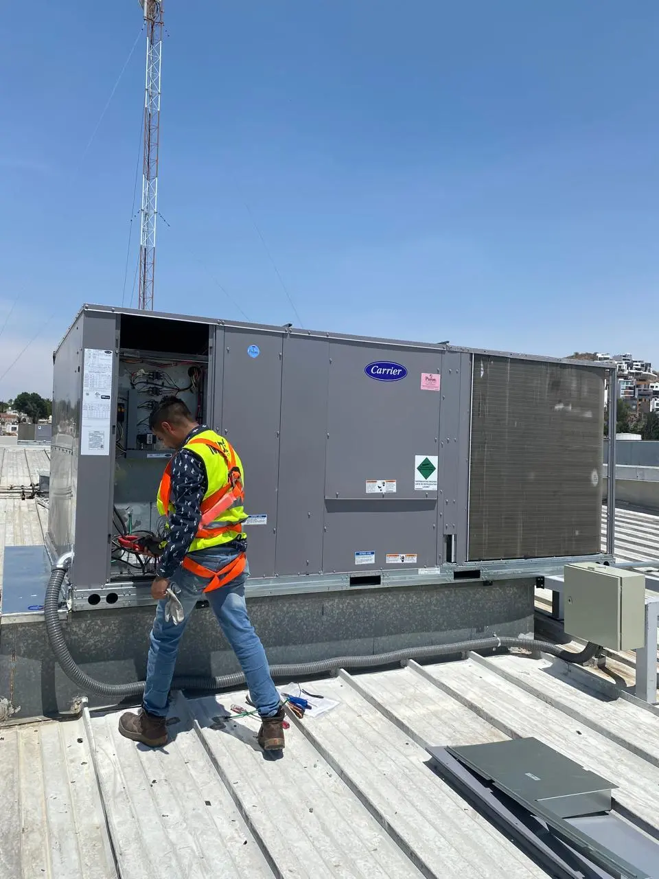 Técnico revisando un equipo de aire acondicionado comercial en una azotea de Guadalajara